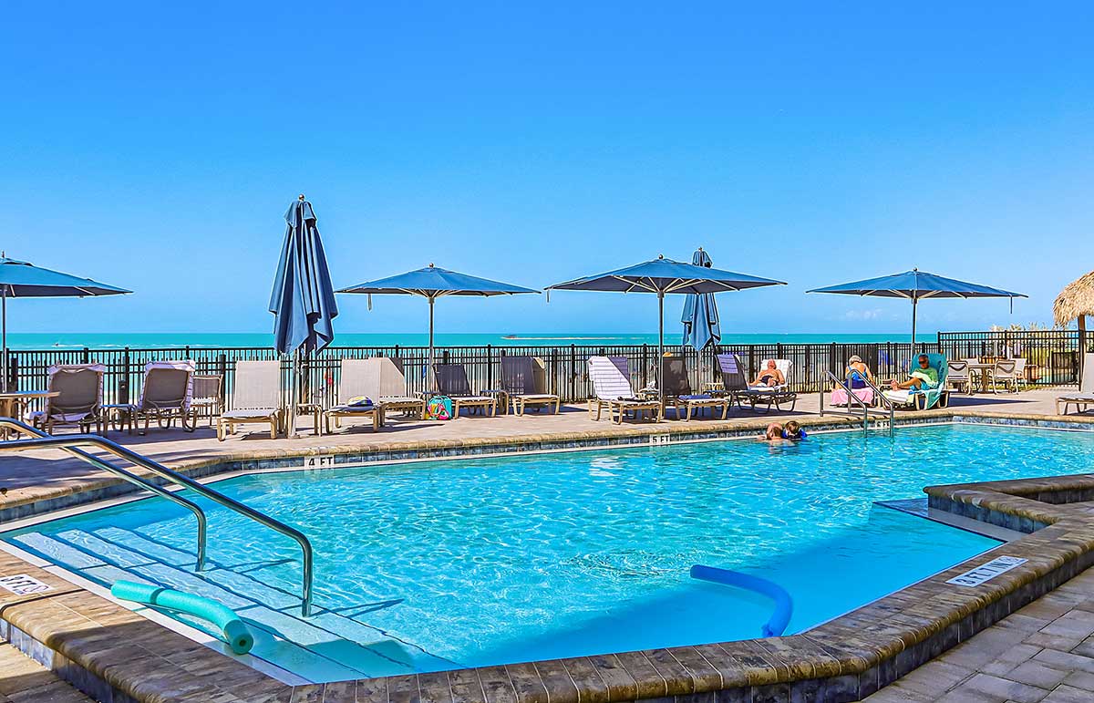 Beachfront pool with umbrellas